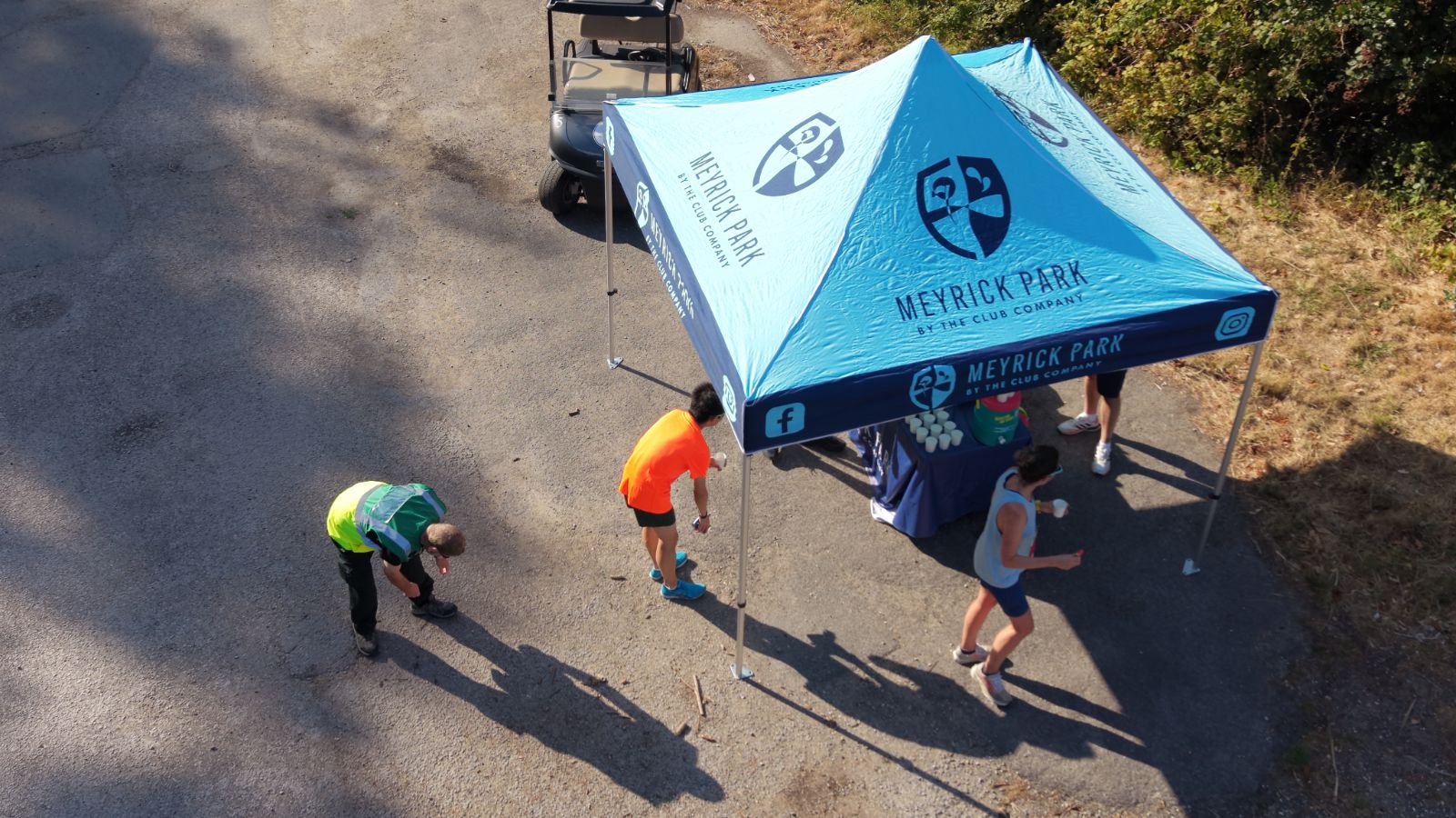 Meyrick Park aid station tent with runners grabbing water