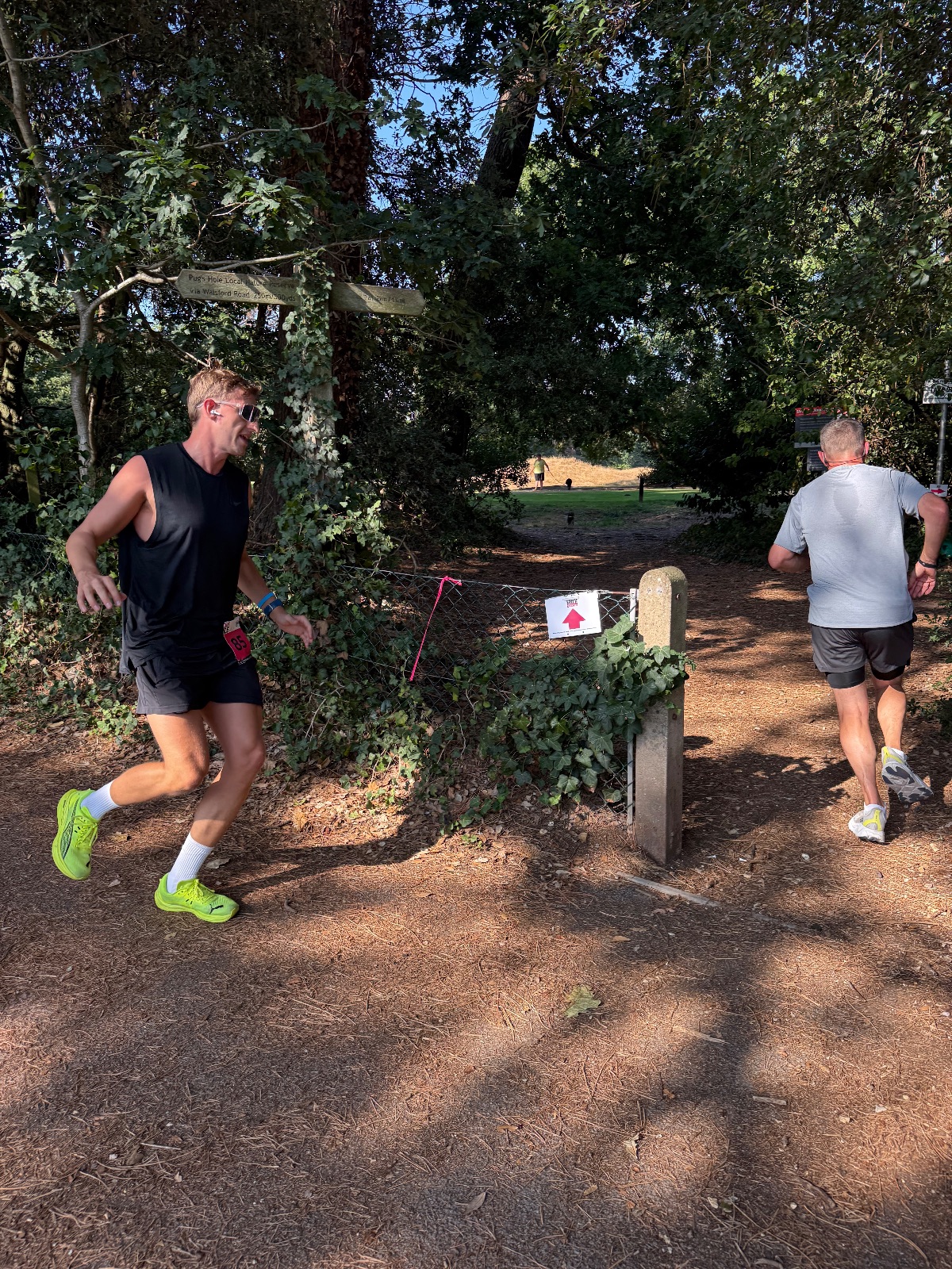 Runners passing the Pug's Hole nature reserve gateway